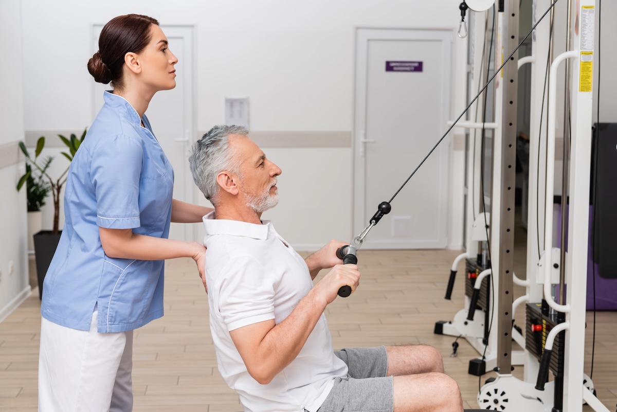 A physiotherapist guiding a patient with their strength exercise.